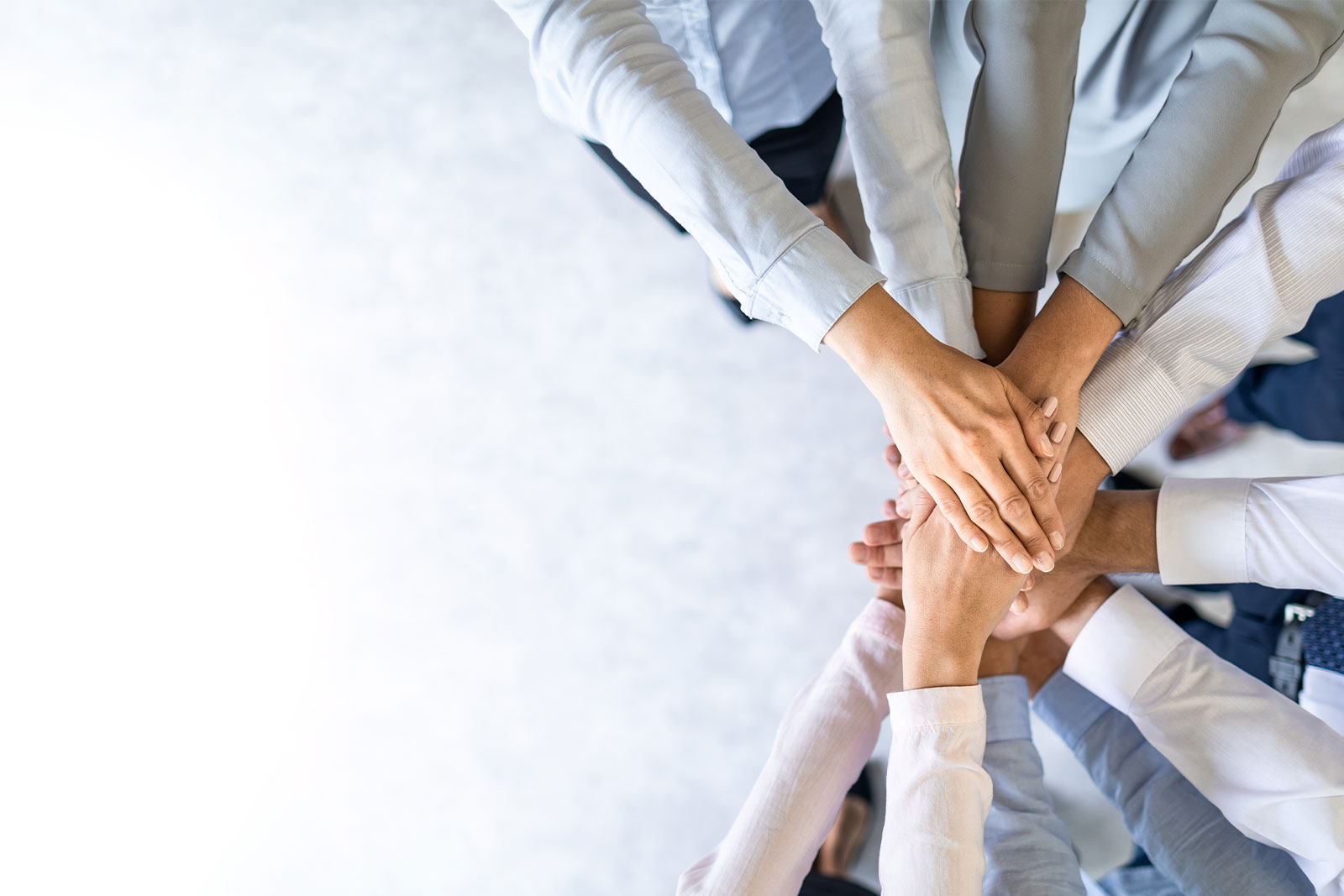 Image of business workers with their hands in a pile.