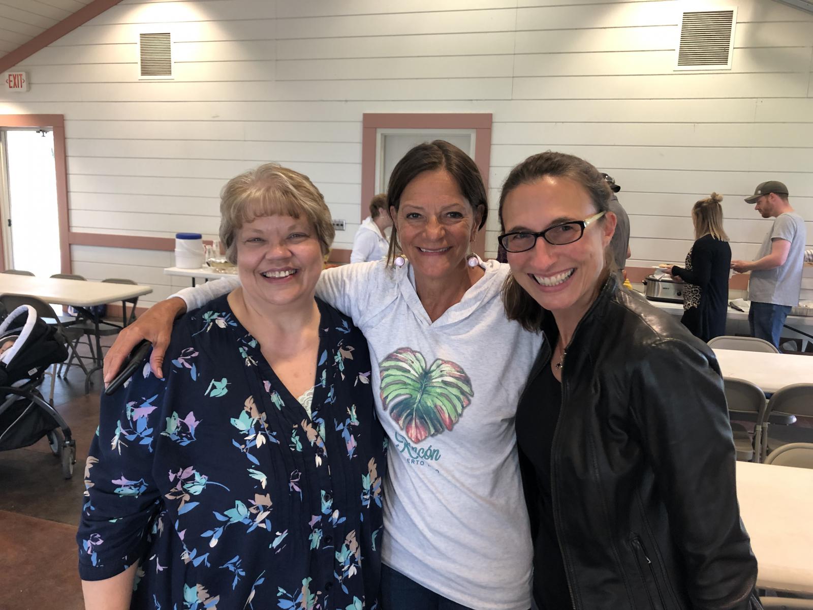 Image of three woman at pot luck